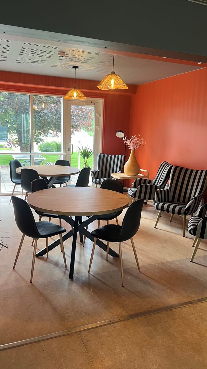 Oleskelutila, oranssi seinä ja raidalliset nojatuolit